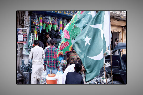 لائٹ ہائوس مارکیٹ کے قریب شہری یوم آزادی کے حوالے سے قومی پرچم کی خریداری میں مصروف ہیں