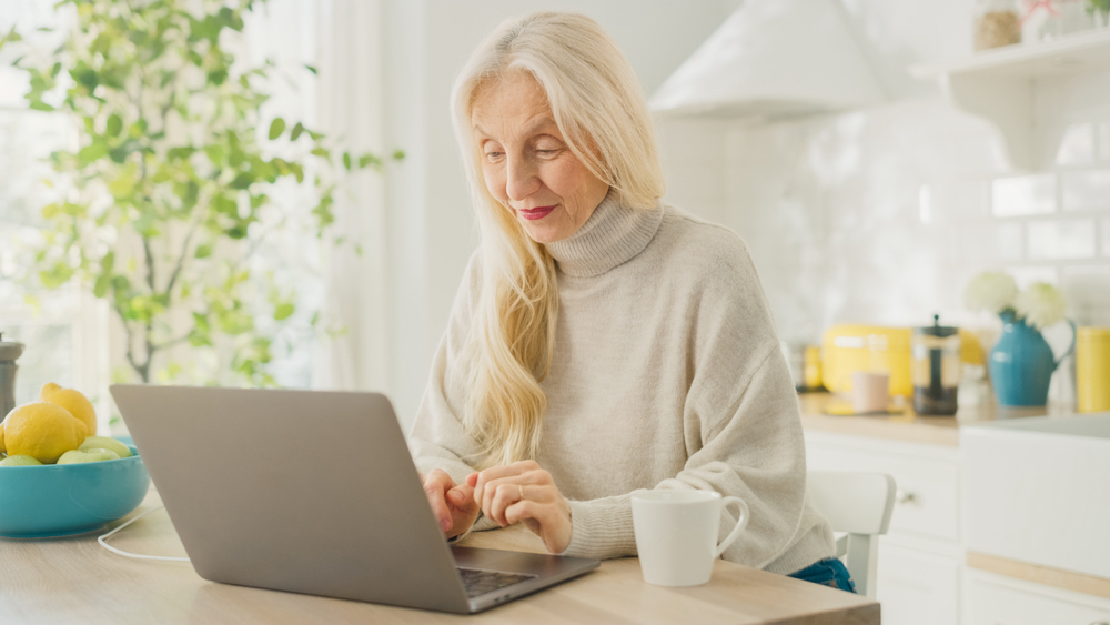 A female retiree earning extra money from home on laptop.png