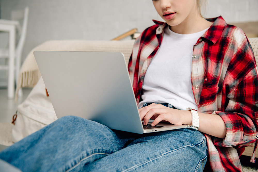 Female teen making money from home on her laptop.png