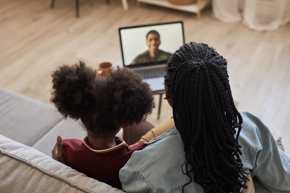 Military spouse and daughter having a video call with their loved one .png