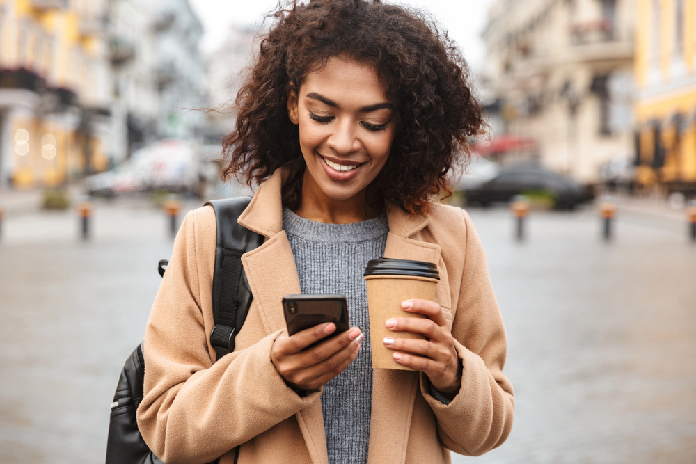 Woman using cell phone apps to make money.png