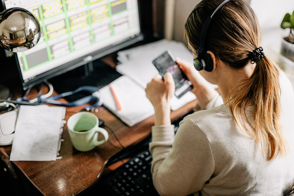 Young woman sitting at desk taking calls for her new work from home no experience job.png