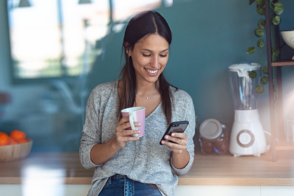 Young woman using smartphone to make money with inboxdollars.png