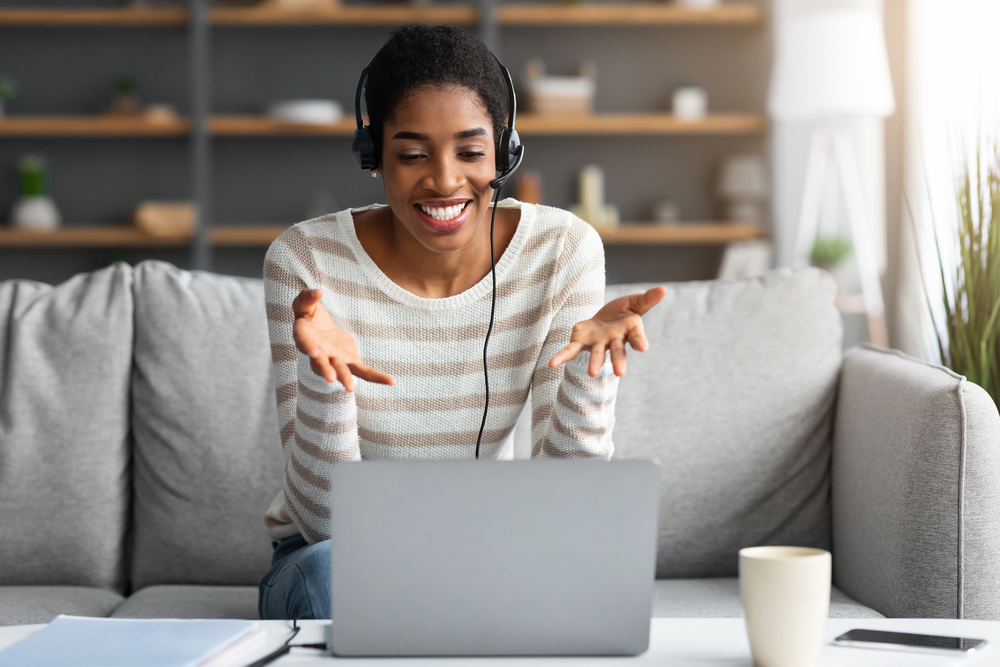 Young woman wearing a headset taking calls for hre remote customer service job.png