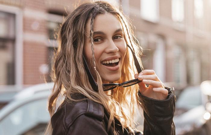A close up of a happy woman with a baddie rubber band hairstyle.jpg
