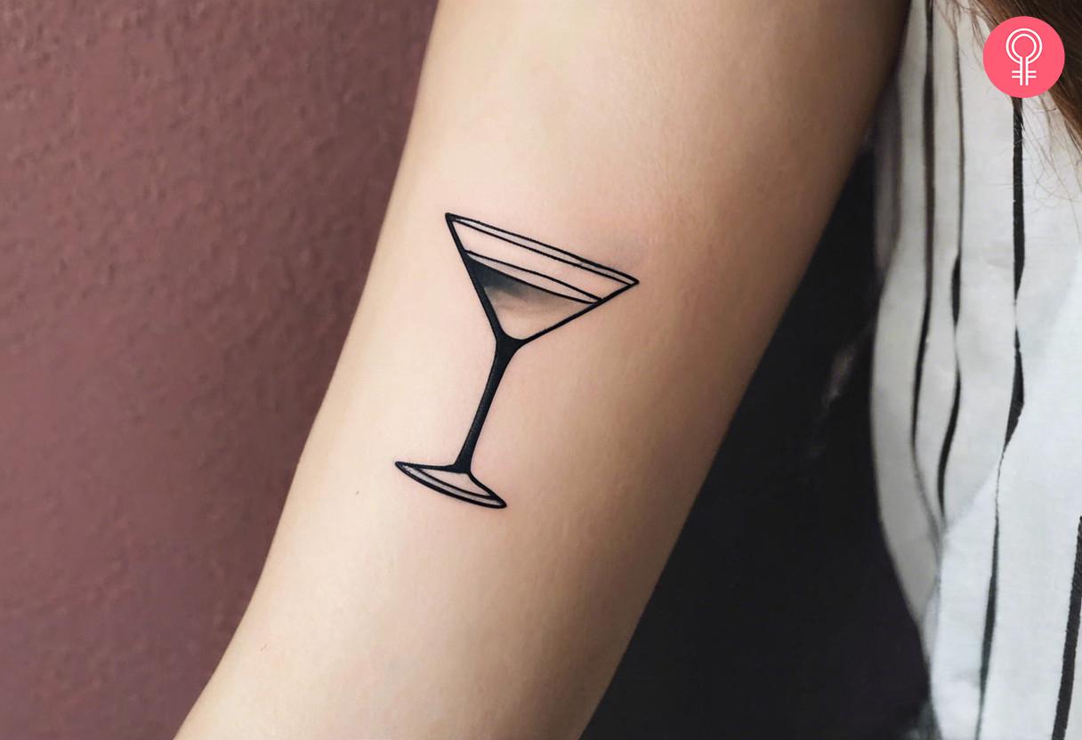 A tiny martini tattoo on the forearm inked in black.jpg