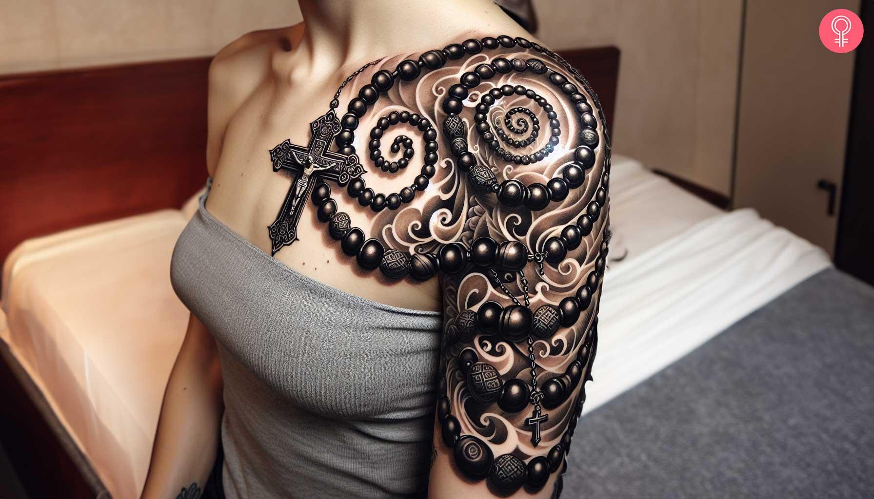 A woman with a black rosary beads tattoo on her upper arm and shoulder.jpg