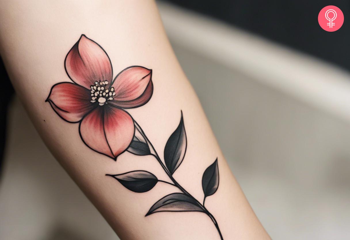 A woman with a minimalist dogwood flower tattoo on her forearm.jpg