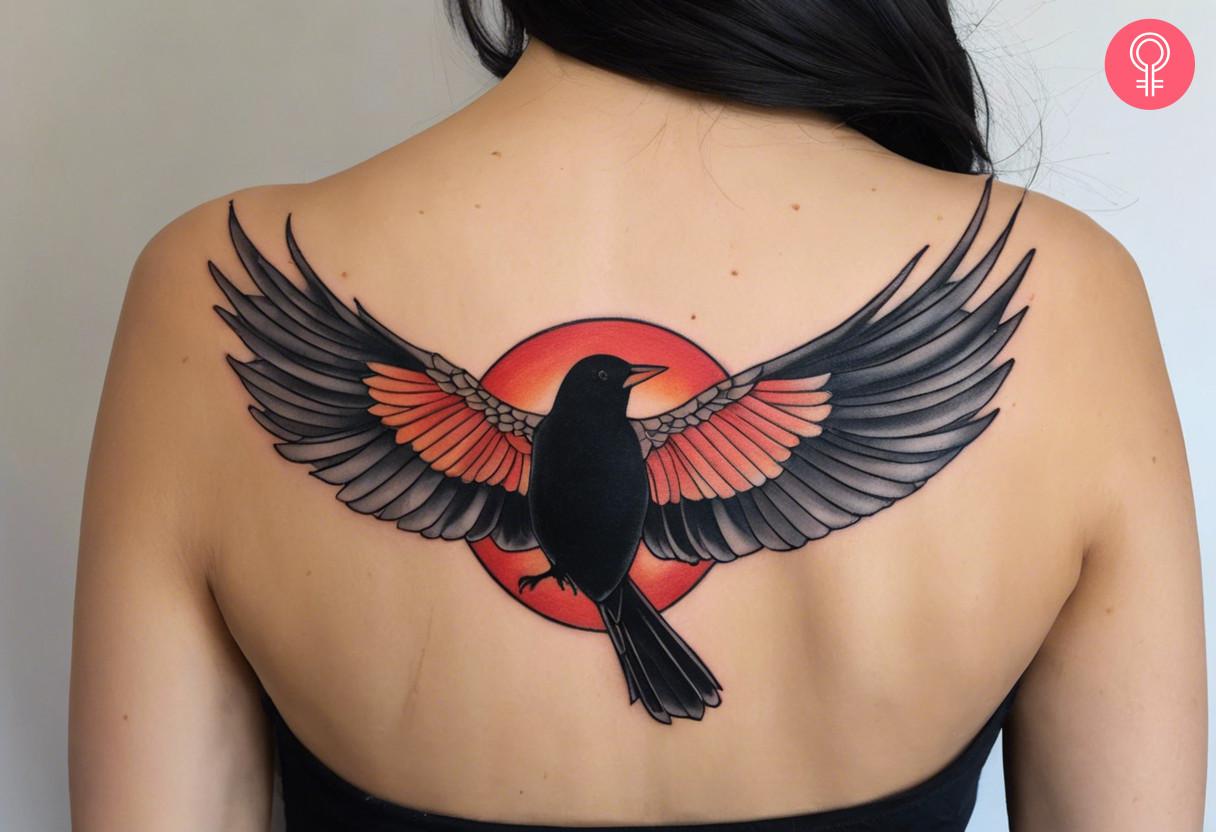 A woman with a red winged blackbird tattoo on her back.jpg