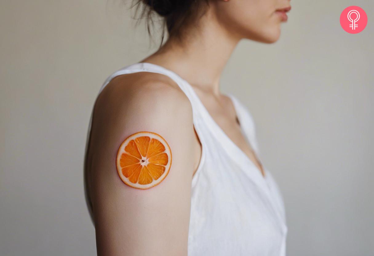 A woman with a vibrant orange slice tattoo on her upper arm.jpg