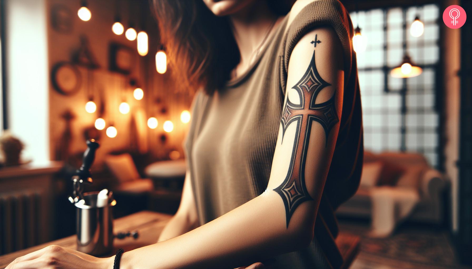 An upper arm tattoo of a red Crusader Cross.jpg