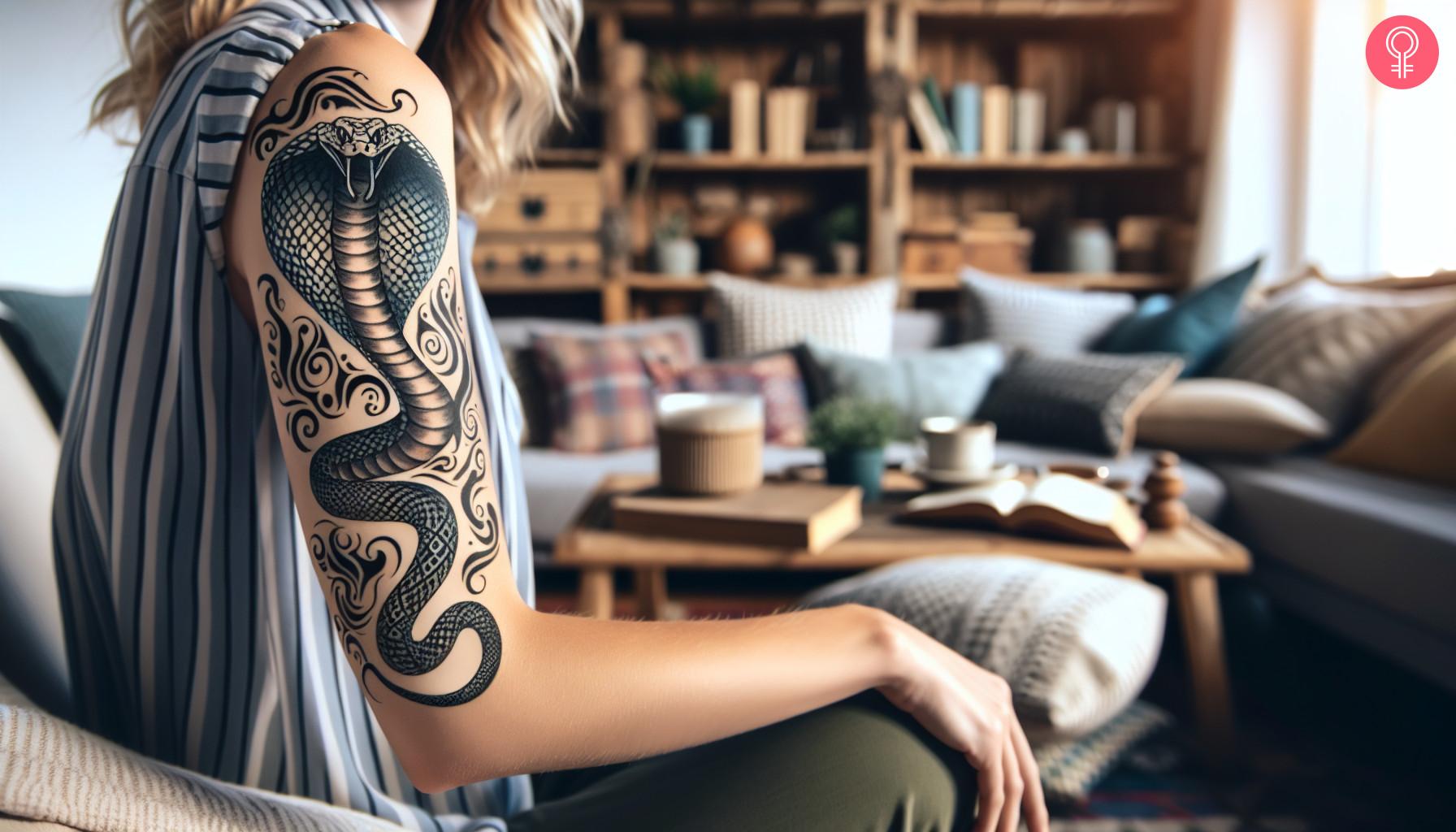 Tribal cobra tattoo on the upper arm of a woman.jpg