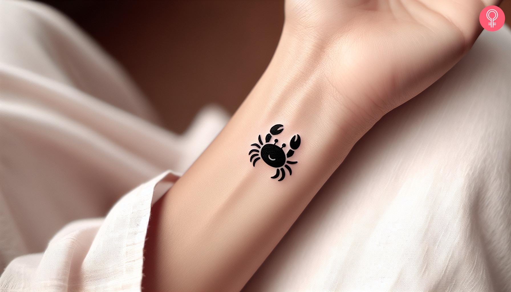 Woman wearing a cancer zodiac tattoo on her wrist.jpg