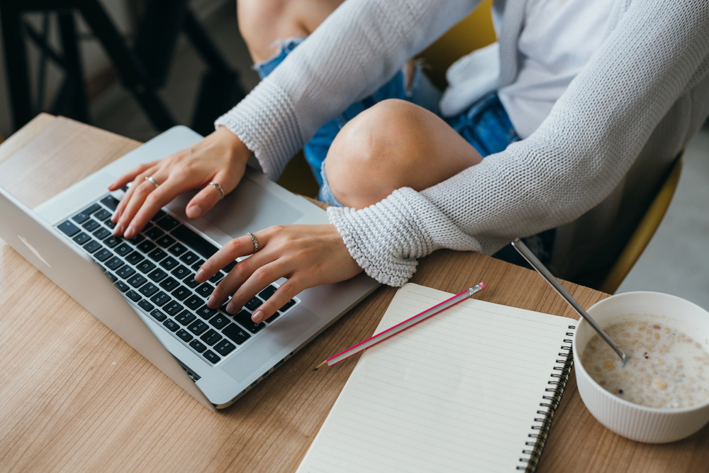 A young woman on her laptop searching for online chat agent jobs.png