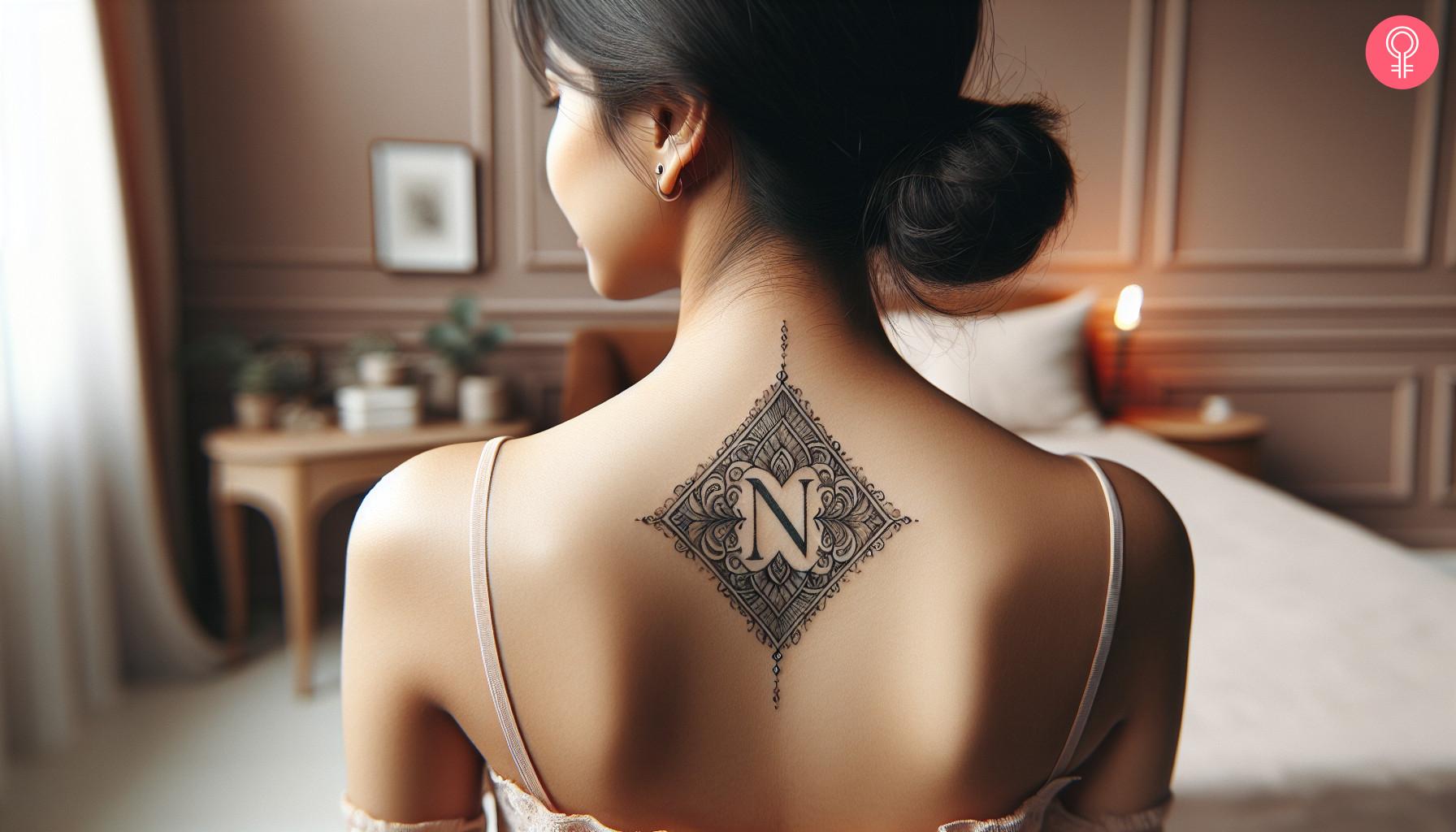 An N letter tattoo on the upper back of a woman.jpg