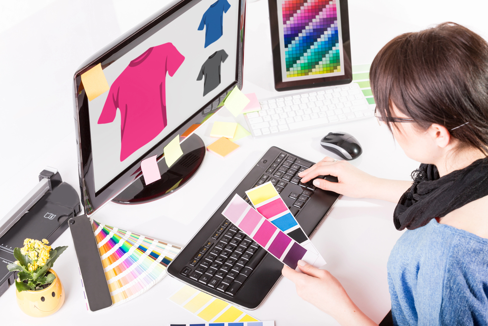 A woman sitting at her computer trying to make money designing t shirts online.jpeg