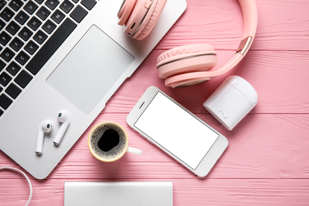 A overview image of a music lovers desk with headphones phone laptop coffee and ipods.jpeg