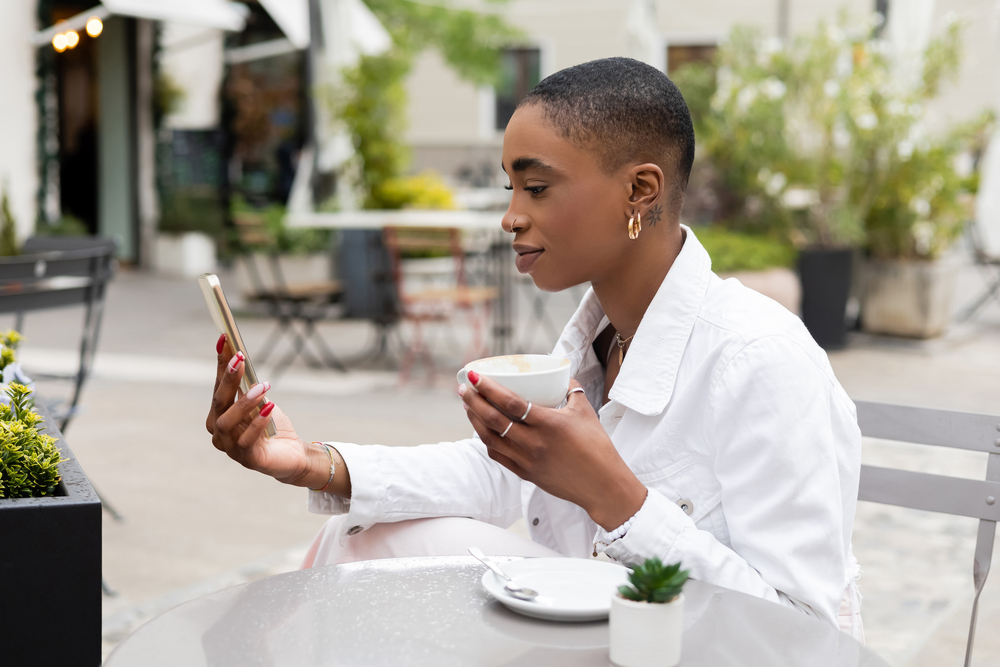 A woman sitting outdoor drinking coffee getting paid to surf the web.jpeg