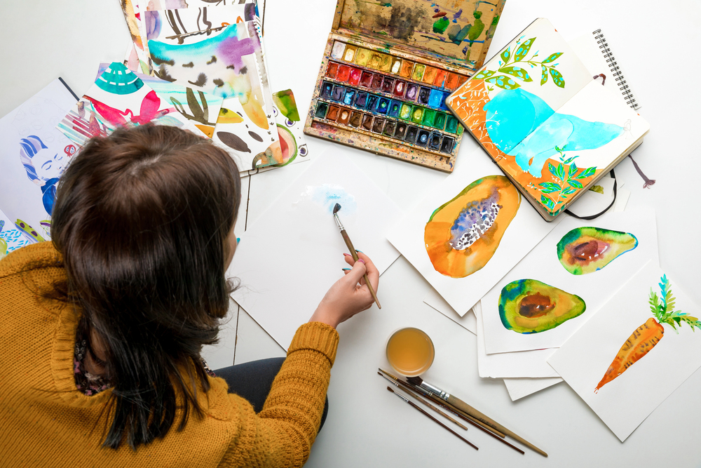 A woman painting to sell art online.jpeg