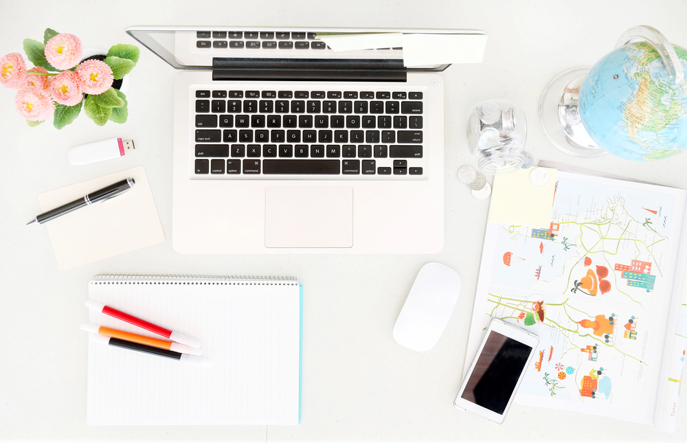 Overview of a desk space with laptop and globe for worldwide work from home jobs.jpeg