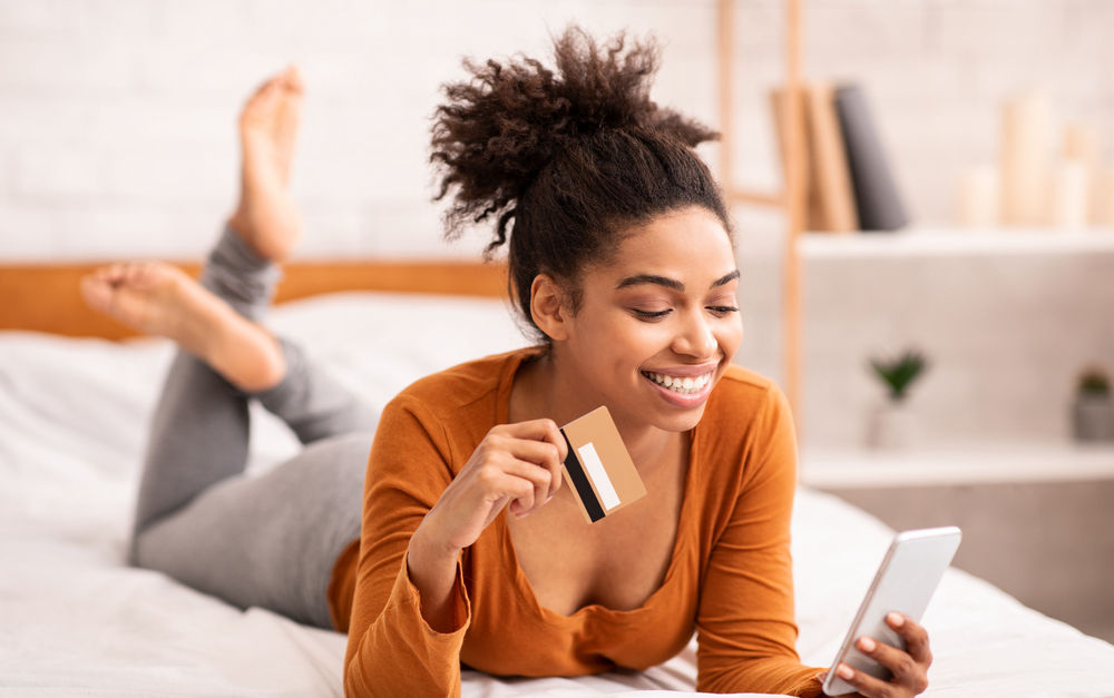 Young woman using her smartphone to earn free Amazon gift cards online.png